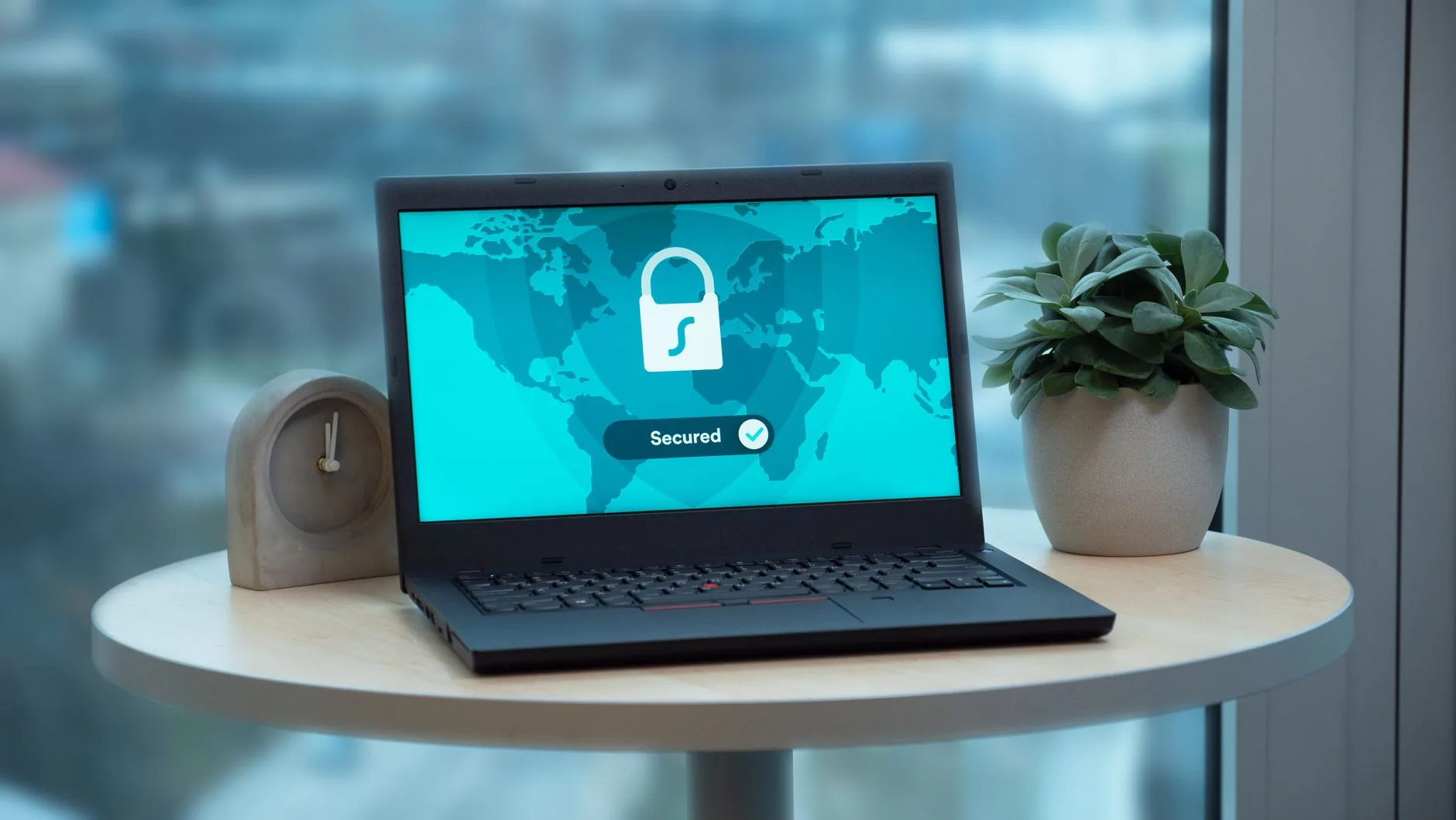 Ordinateur portable affichant un cadenas et le mot Secured sur fond de carte du monde turquoise